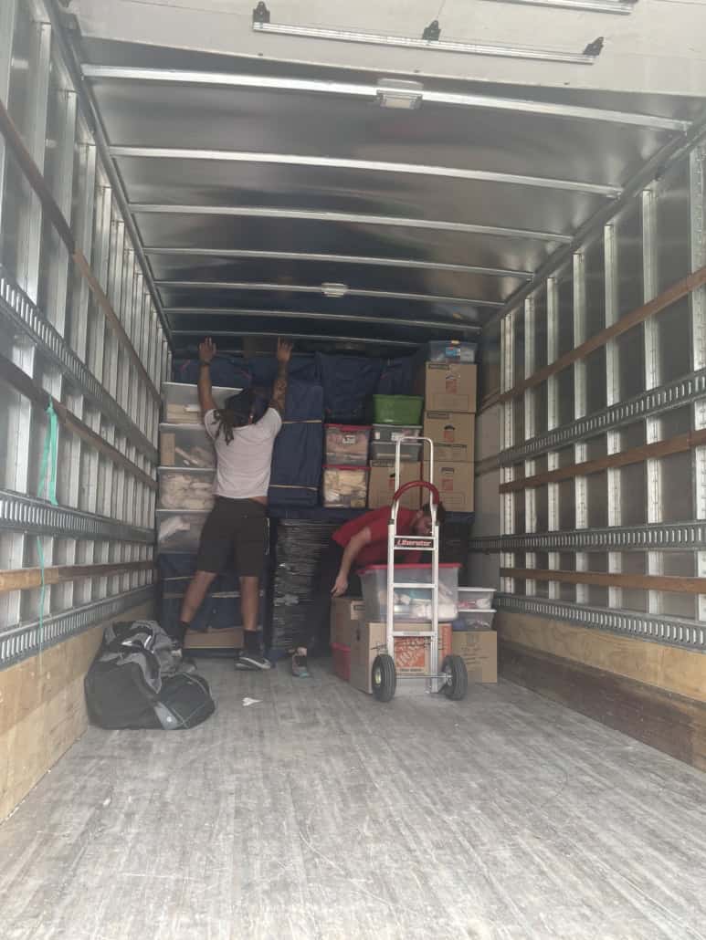 Moving truck interior with packed boxes and moving supplies.